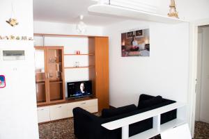 sala de estar con sofá y TV en Da Romano, en San Giacomo