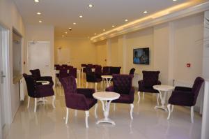 a conference room with tables and chairs and a whiteboard at Hotel Iscen in Mustafakemalpaşa