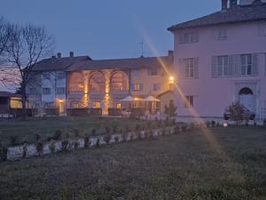 a large white house with a lit up facade at Villa San Giorgio Guest House in Serravalle Scrivia