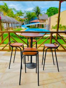 una mesa con 2 sillas y una mesa con piscina en POUSADA OBAH VILLAGE, en Prea