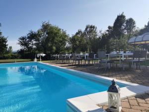 a swimming pool with a table and chairs next to it at Villa San Giorgio Guest House in Serravalle Scrivia