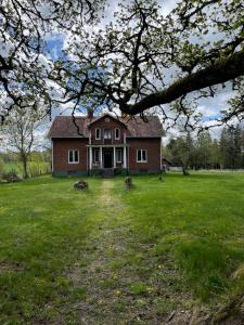 una casa grande en un patio de césped con un árbol en Villa Walterängen, en Tibro