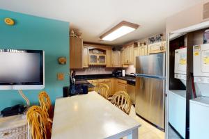Il comprend une cuisine équipée d'un réfrigérateur et d'une table avec des chaises. dans l'établissement Club Ocean Villa 2 33, à Ocean City