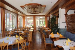 ein Restaurant mit Holztischen, Stühlen und Fenstern in der Unterkunft Landgasthof Hotel Lamm in Laichingen