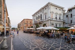 a street with tables and chairs and people walking down a street at B&B Lanciano in Lanciano