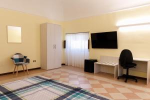 a room with a bed and a desk and a television at B&B Lanciano in Lanciano