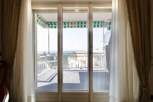 d'une porte coulissante en verre avec vue sur un balcon. dans l'établissement Sanremo Dream - Casa Achille, à Sanremo
