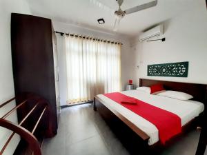 1 dormitorio con 1 cama grande con manta roja en Cinnamon Apartment Panadura, en Panadura