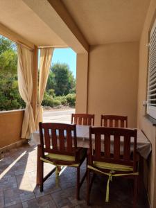 a dining room with a table and two chairs at Apartments Bagić in Vir