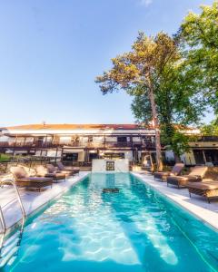 a swimming pool with lounge chairs and a building at Boutique Hotel Annuska in Balatonfüred