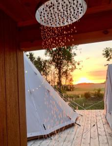 una lámpara de araña y una marquesina en una boda en Cowcooning / Family tents en Huldenberg