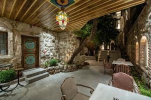 a patio with a table and chairs and a chandelier at Foremanson Cave Hotel in Nar