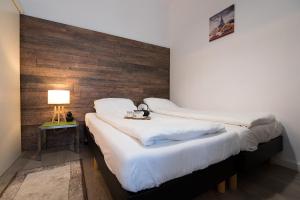 Duas camas num quarto com uma parede de madeira em Ultra Central Bohemian Apartment 1 em Cluj-Napoca
