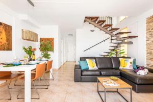 uma sala de estar com um sofá preto e uma mesa em Beachfront triplex with swimming pool & parking em Radazul