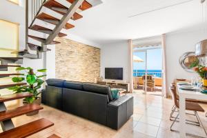 uma sala de estar com um sofá de couro preto e uma sala de jantar em Beachfront triplex with swimming pool & parking em Radazul
