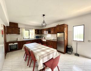 una cucina con tavolo, sedie e frigorifero di Duas Sentinelas - Private Pool by HD PROPERTIES a Quarteira