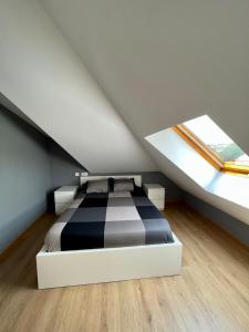 1 dormitorio con 1 cama en blanco y negro en el ático en Villa Churiana, en Camariñas