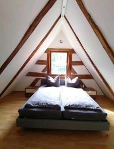 a bedroom with a bed in a attic at Loft auf altem Gutshof in Kirchensittenbach