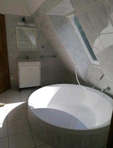 a large white bath tub in a bathroom at Loft auf altem Gutshof in Kirchensittenbach
