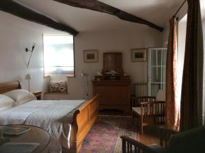 1 dormitorio con cama, mesa y ventana en La Bergerie, en Gurs