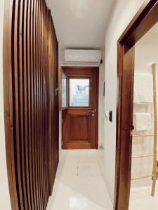a hallway with a wooden door and a window at Archo Suites Pythagoreio in Pythagoreio