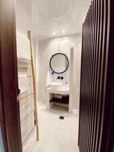 a bathroom with a sink and a mirror at Archo Suites Pythagoreio in Pythagoreio