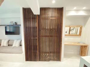 a wooden partition in a room with a bed at Archo Suites Pythagoreio in Pythagoreio