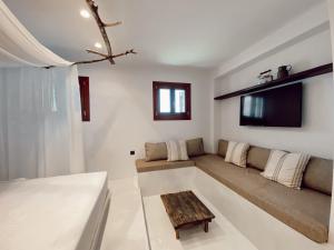 a living room with a couch and a tv at Archo Suites Pythagoreio in Pythagoreio