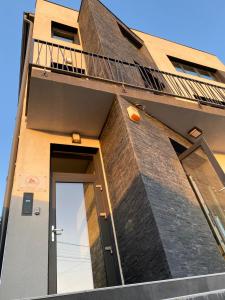 un edificio de ladrillo con puerta y balcón en EM02- Apartament 2 camere luxury, en Târgu Jiu