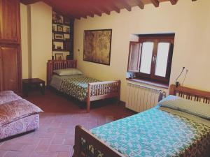 1 dormitorio con 2 camas y ventana en Castello di Urbech en Pratovecchio
