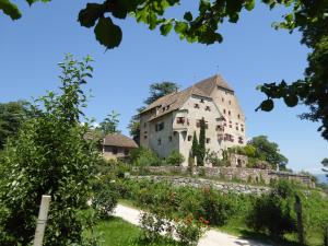 un grand bâtiment sur une colline avec un jardin dans l'établissement Schloss Englar, à Appiano sulla Strada del Vino