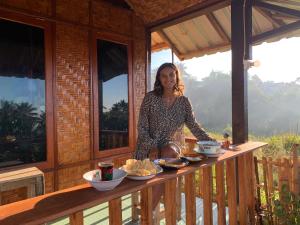 a woman sitting at a table in a cabin at Kurni's Cabin in Sapit
