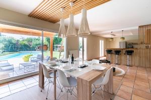 cocina y comedor con mesa y sillas en Signoret - Belle maison avec piscine, en Toulouse