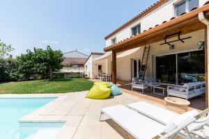 un patio con sillas y una piscina en Signoret - Belle maison avec piscine, en Toulouse