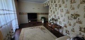 a living room with a tv and a wall with pictures at Ventas in Liepāja