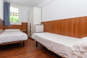 a bedroom with two beds and a window at Rentalmar Family Felix con parking incluido in Salou