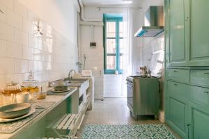 a kitchen with mint green cabinets and a sink at Teatro Massimo Bright and Cozy Apartment in Palermo