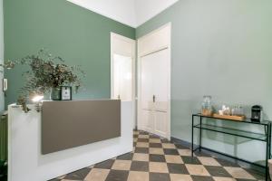 a hallway with green walls and a checkered floor at Teatro Massimo Bright and Cozy Apartment in Palermo