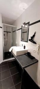 uma casa de banho branca com um lavatório e um chuveiro em La Ferme du Soyeuru em Spa