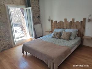 Schlafzimmer mit einem großen Bett mit einem Kopfteil aus Holz in der Unterkunft La Vigneronne du 7 in Bouzigues