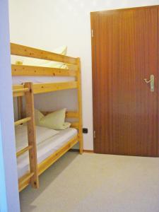 Zimmer mit 2 Etagenbetten und einer Tür in der Unterkunft Gschwendtnerhof App17 Blum in Aschau im Chiemgau
