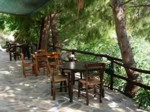 a group of tables and chairs sitting under a tree at Sisaion Suites - Live the Cretan Hospitality in Metókhion Apisianá