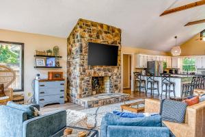 uma sala de estar com uma lareira de pedra e uma televisão em The Blue Heron Retreat em Bumpass
