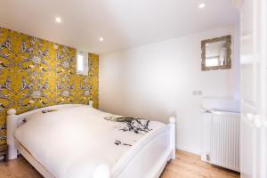 a bedroom with a white bed and yellow wallpaper at Vakantiehuis Domburg Cabanas DO37 in Domburg