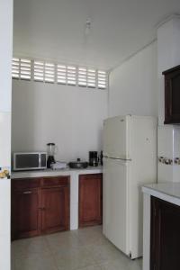 eine Küche mit einem weißen Kühlschrank und Holzschränken in der Unterkunft Casa en Honda La Casa de Flor en el barrio Guali in Honda