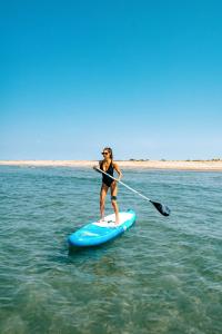 a woman on a paddle board in the water at Hôtel Plage Palace & Spa in Palavas-les-Flots