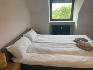 1 dormitorio con 1 cama blanca y 2 toallas en Old town comfort and cozy apartment, en Dachau