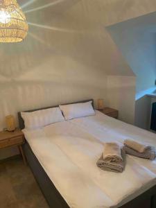a large white bed with two towels on it at Old town comfort and cozy apartment in Dachau