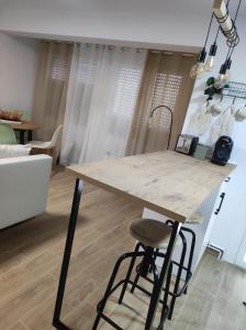 isla de cocina con encimera de madera y taburete en Apartamentos La Casa del Maestro, en Alhama de Aragón