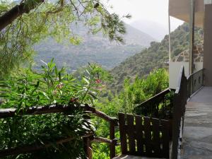 a view of the mountains from a house with a bench at Sisaion Suites - Live the Cretan Hospitality in Metókhion Apisianá